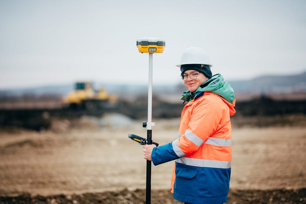 Surveyor menggunakan theodolite digital untuk pekerjaan stake-out di lapangan